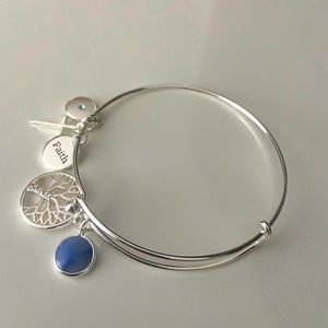 Silver cuff bracelet with faith pendants.